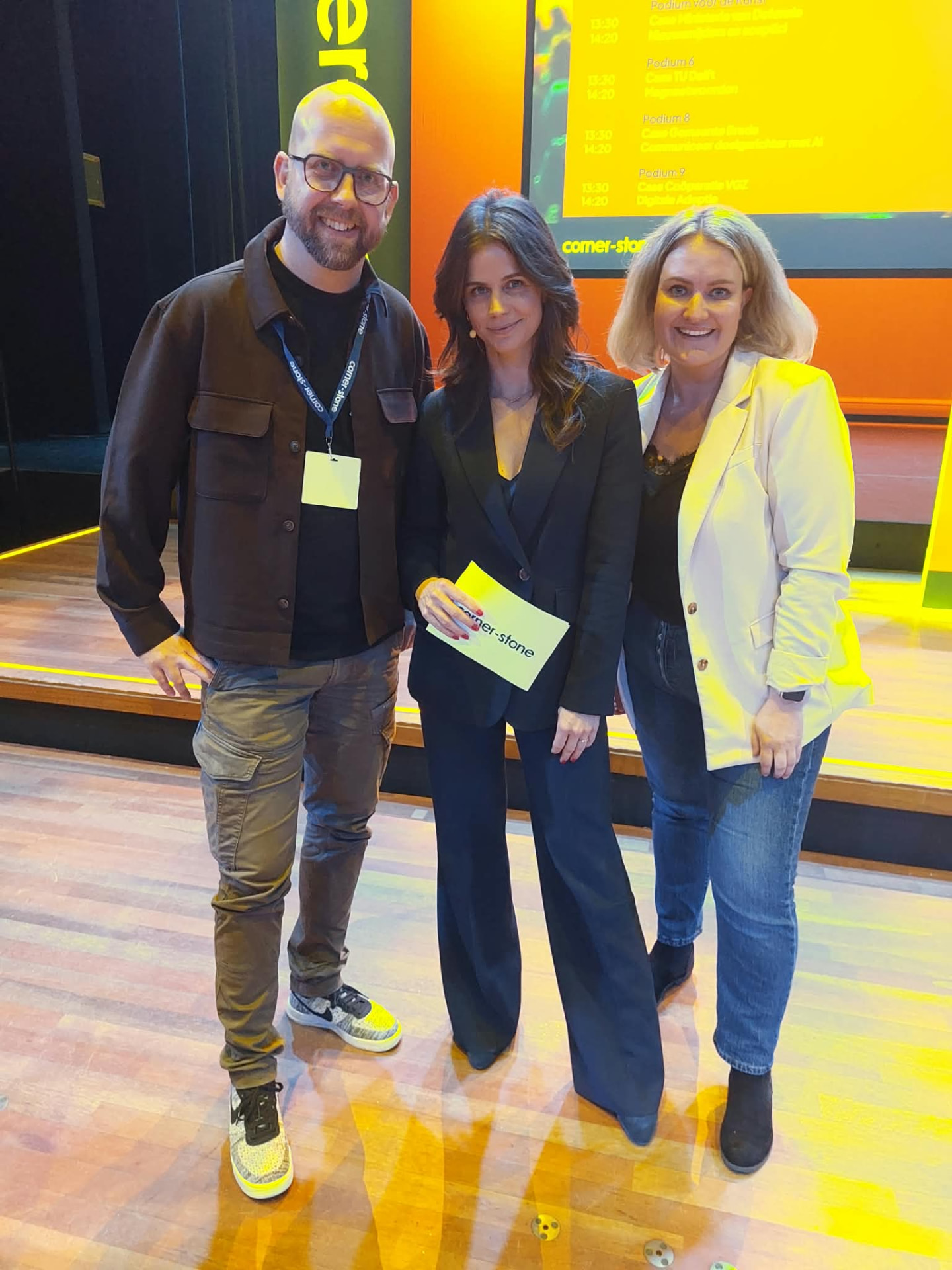 Bas Prins met de dagvoorzitters op het podium van het Praktijkcongres Interne Communicatie 2026